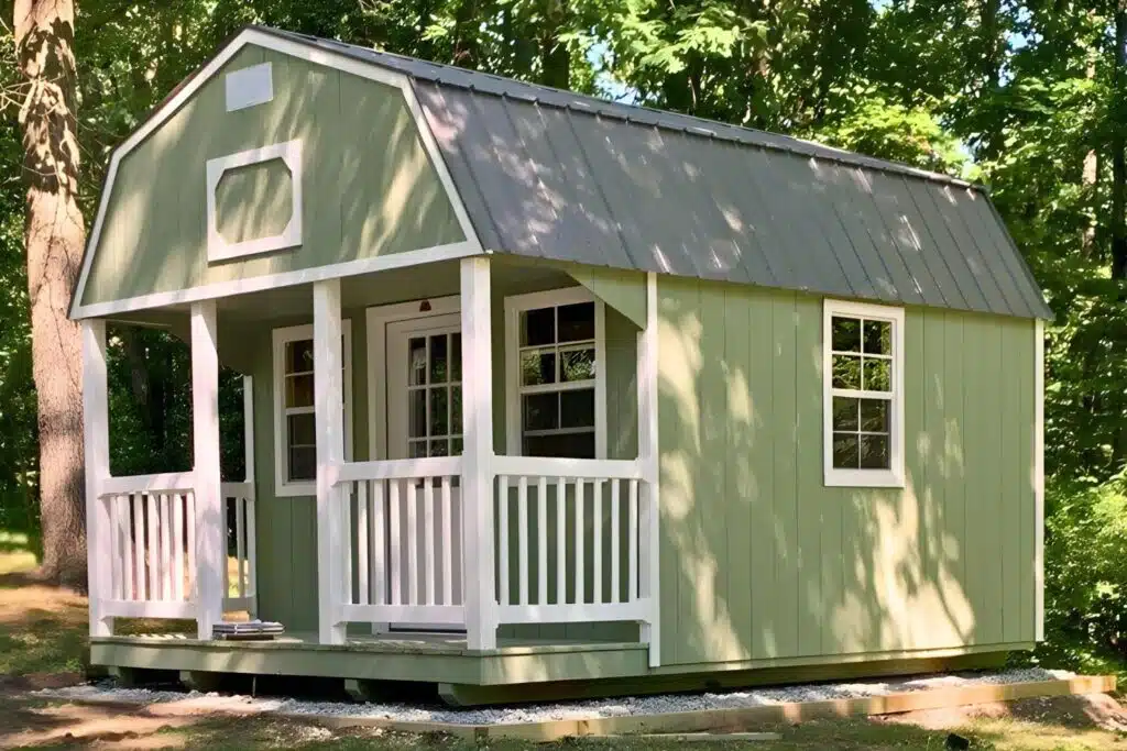 Green, gray, and white backyard cabin with porch in Fremont IN.