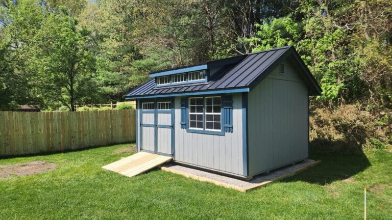 Gray shed with ramp in backyard