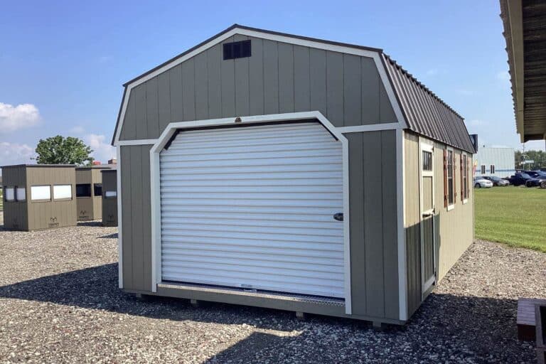 Gray lofted garage with white trim and door in lot