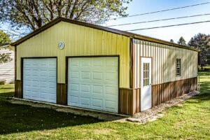 Two-tone tan and brown metal garage with white double doors and clock above